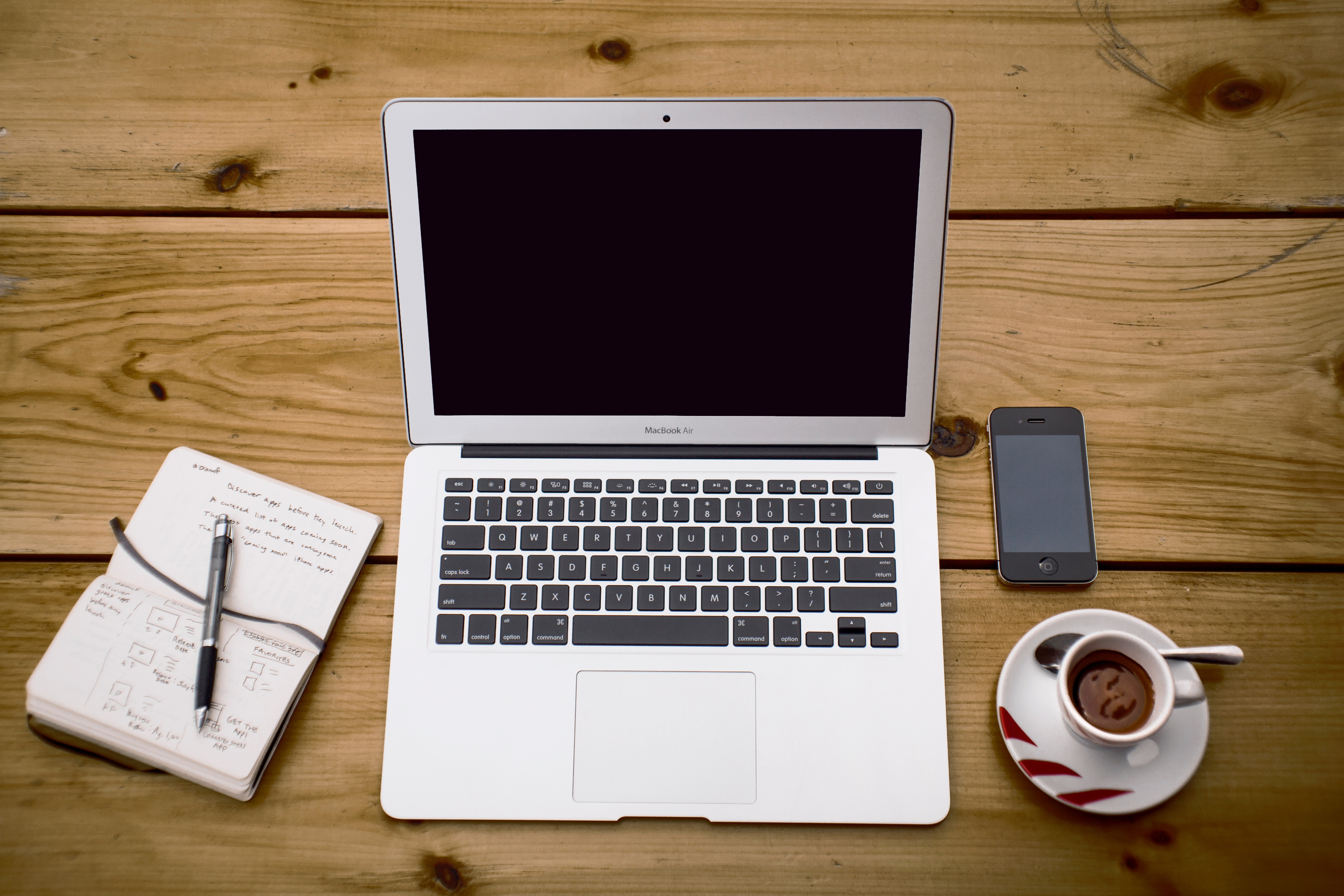 a notebook, laptop and coffee used in content writing services