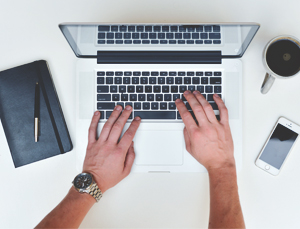 hands, coffee, MacBook, pen, black notebook