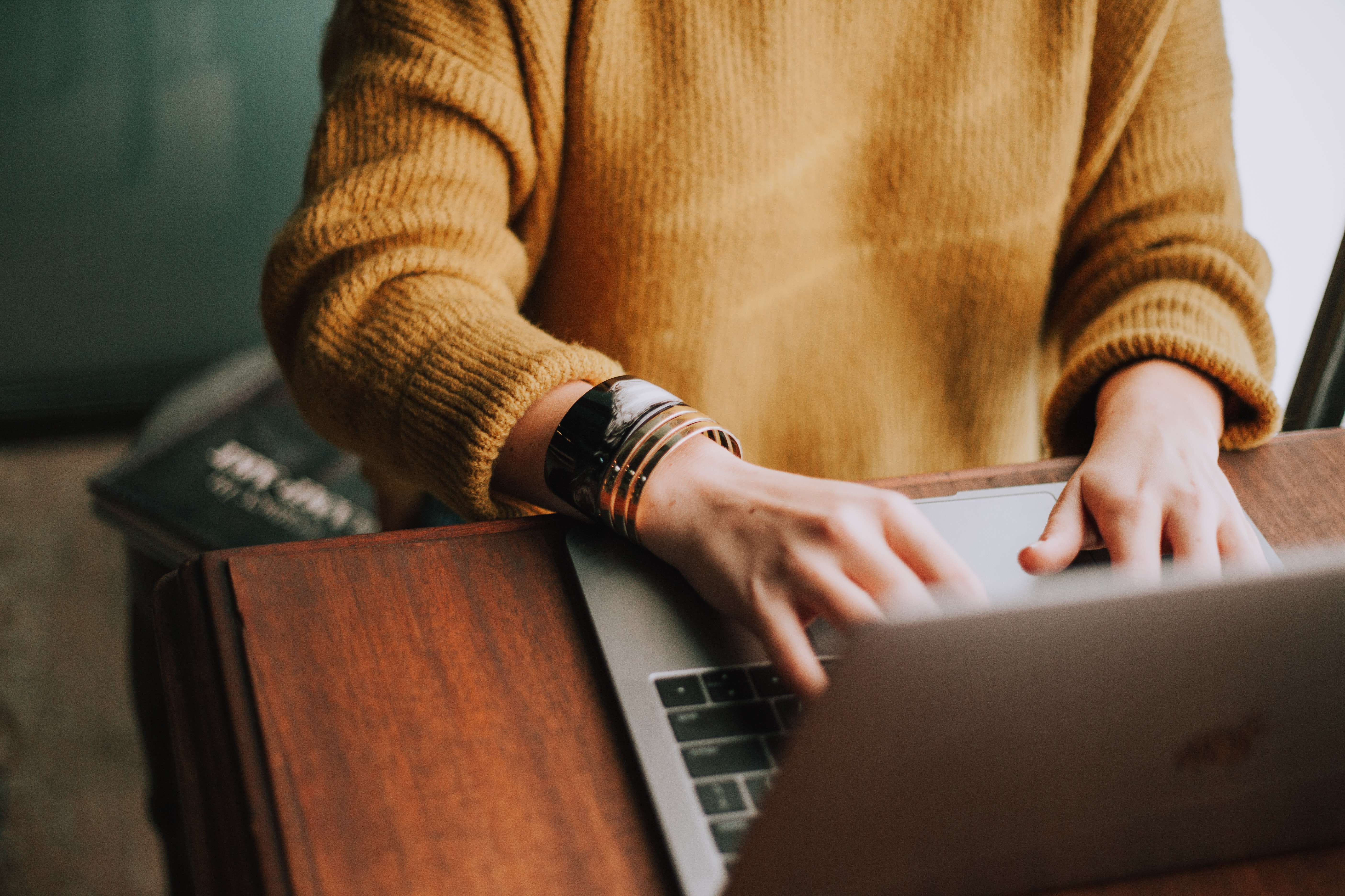 the best content writer wearing yellow while working on a laptop