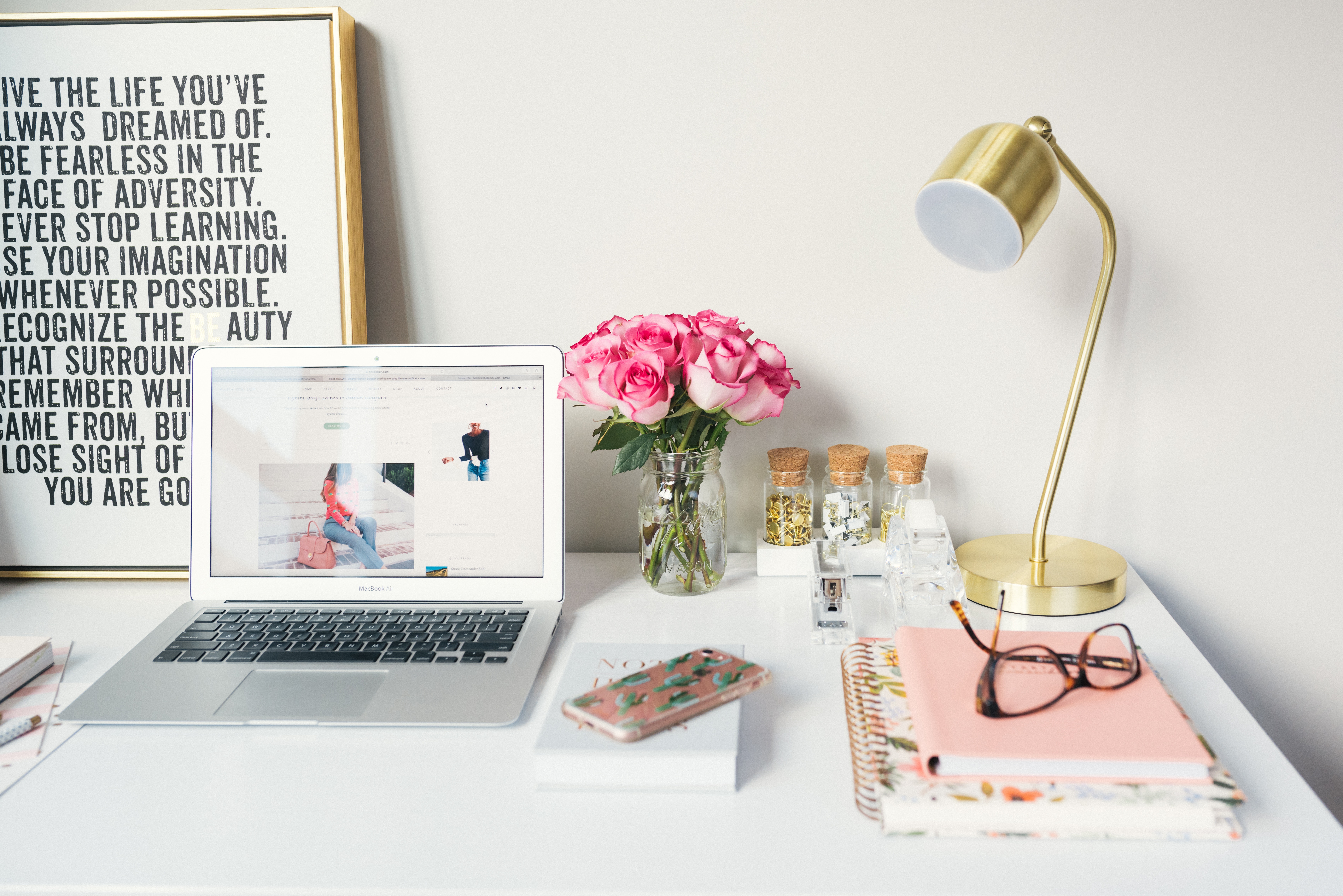 a cute office table with a laptop and papers in its side and following a list of desktop must-haves