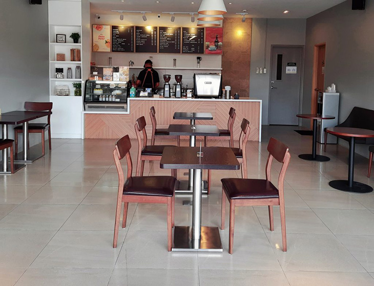 Coffee shop with chairs and tables and barista in the coffee counter