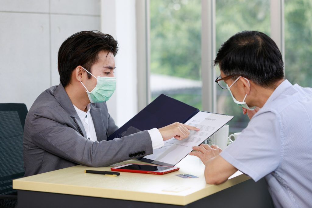 two employees engaging in workplace communication amid the pandemic