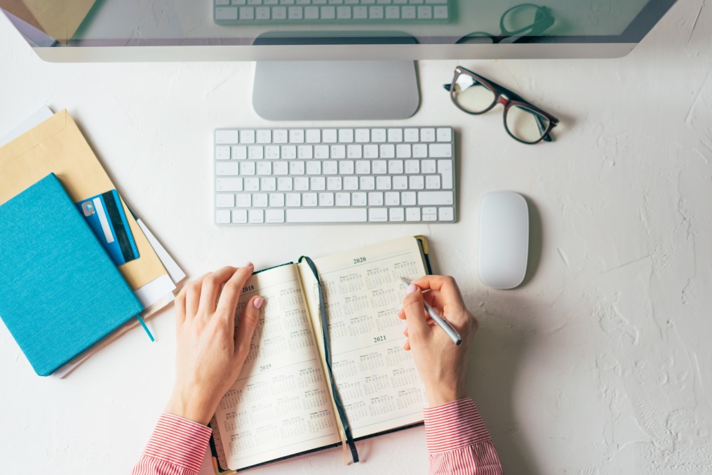 Woman writing steps of career planning process to achieve professional goals on her notebook.