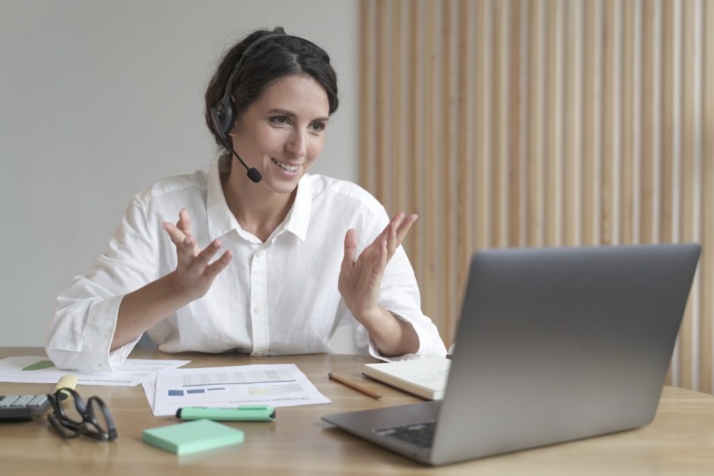 young virtual assistant in headset talking with employer during online meeting