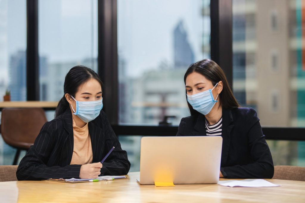 coworkers working together while wearing masks