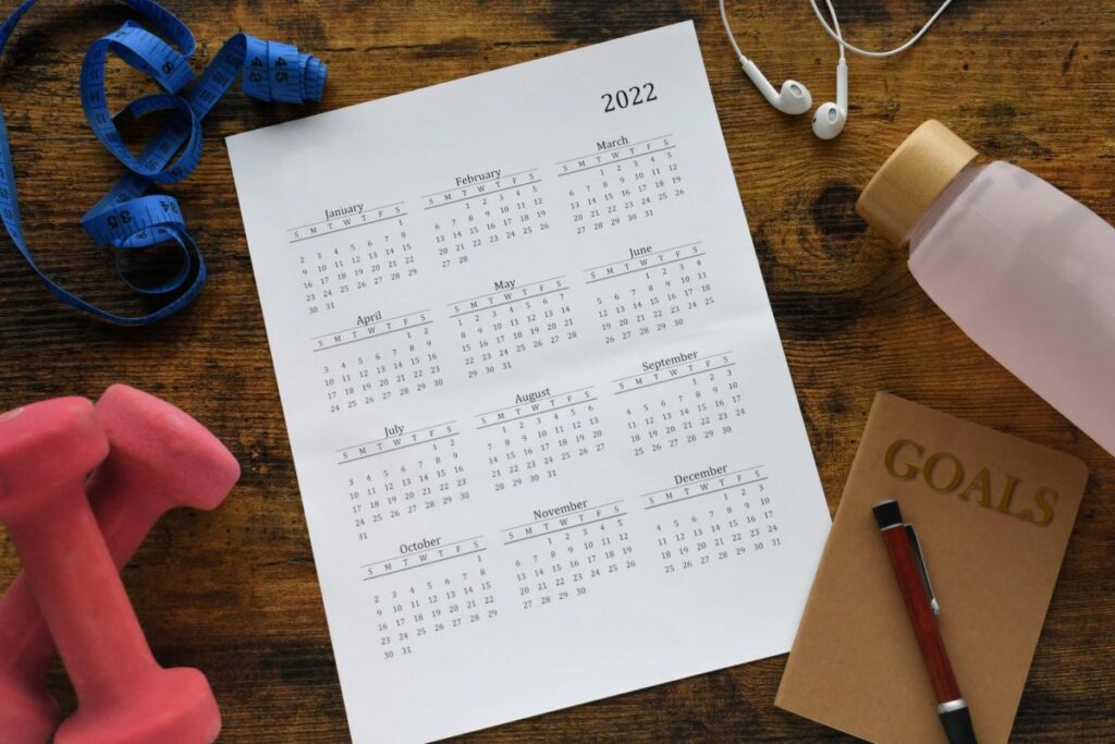 flatlay image of 2022 calendar with a notepad to write one's New Year's resolution