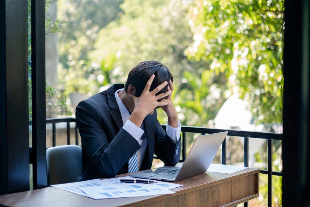 man having headaches from hard work while working