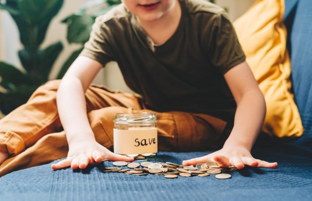 person gathering coins and money to save in a jar