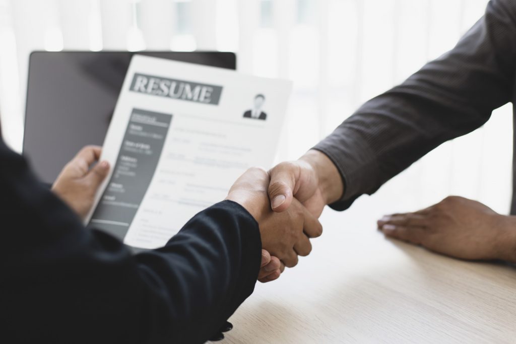 recruiter welcomes new employees by shaking hands