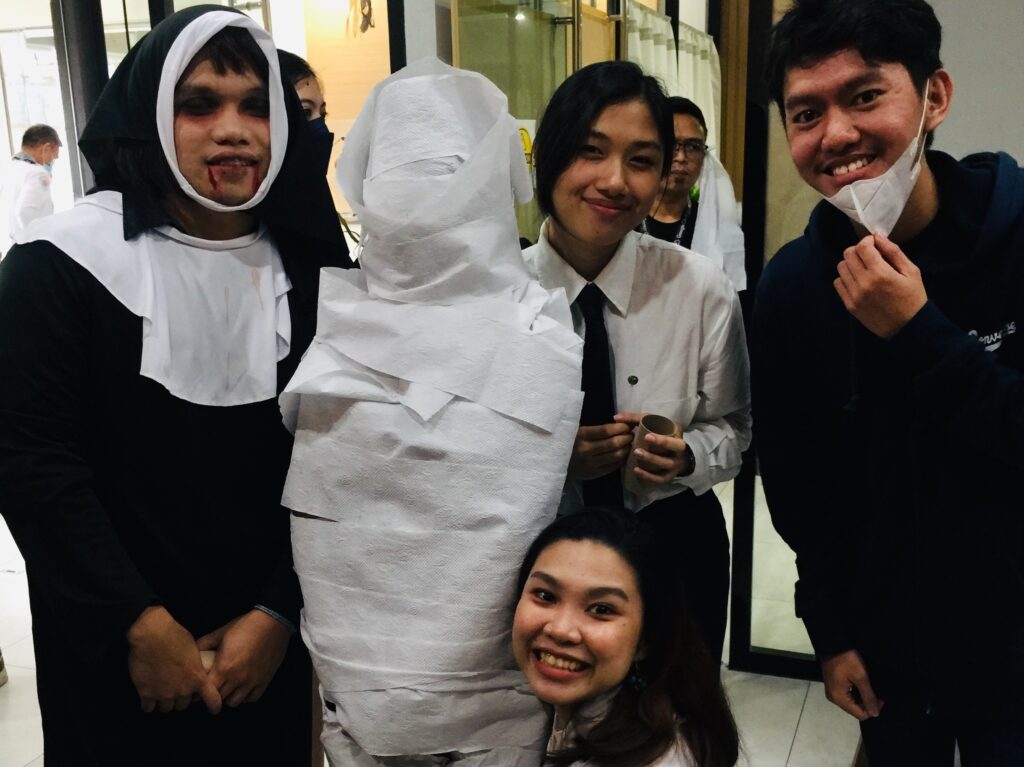 The Digital Content and Marketing and Creative Team with their wrapped mummy.