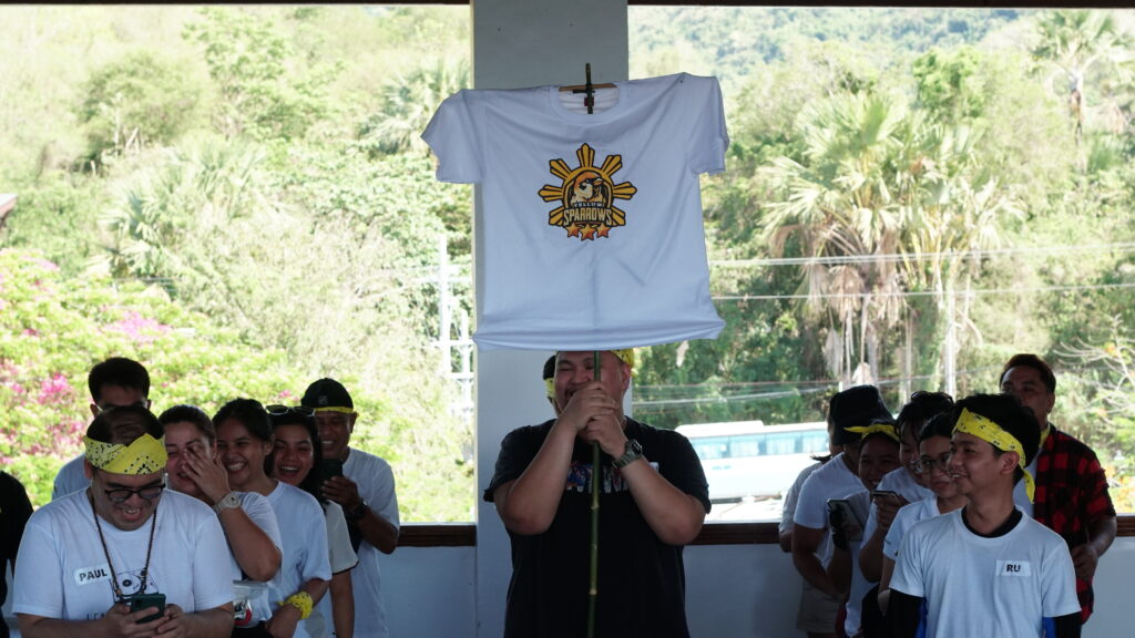 Yellow Sparrows team holding their flag while presenting their cheering number