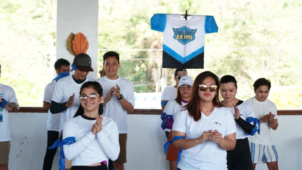 Blue Ravens team cheering as they also hold their flag up