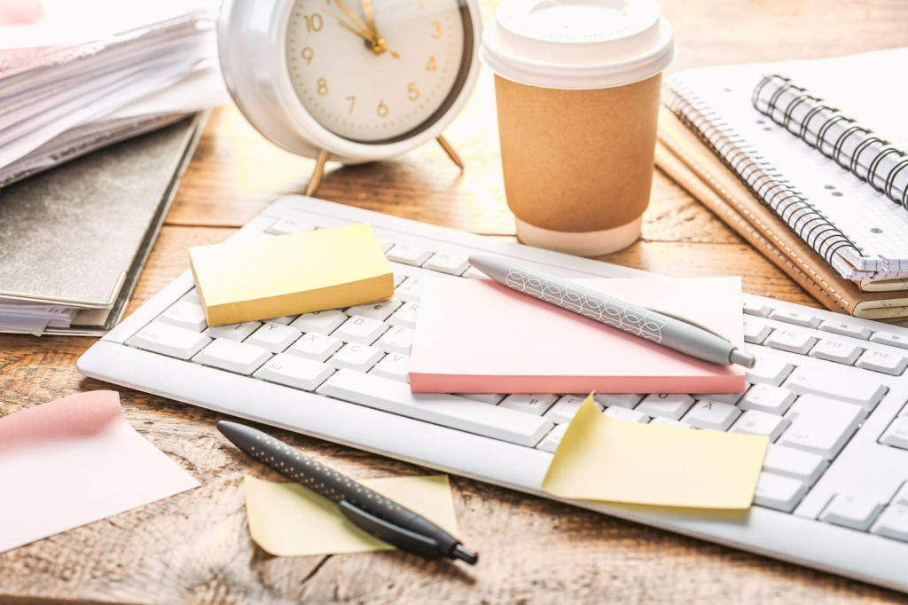 cluttered papers and pens with a clock as a time management concept