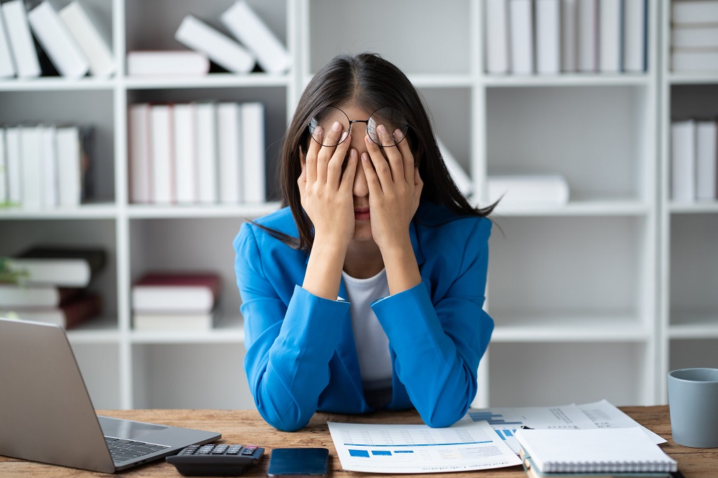 a female employee showing signs of fatigue due to overworking