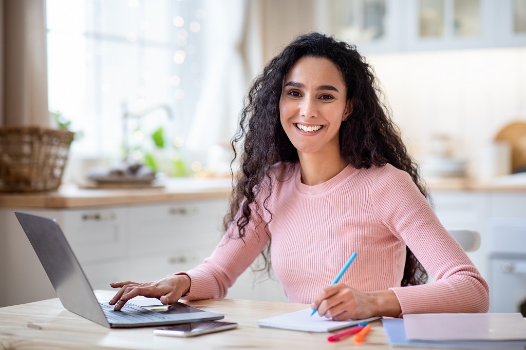 closeup of a young professional smiling confidently while working from home