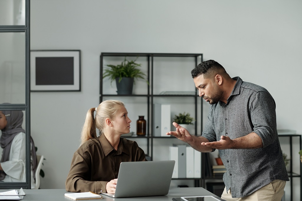 a strict boss closely monitoring an employee’s every move